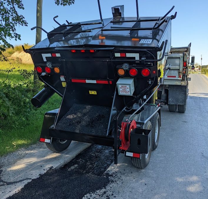 Workers using a Falcon Hot Box to perform pothole patching.