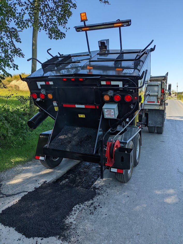 Workers using a Falcon Hot Box to perform pothole patching.