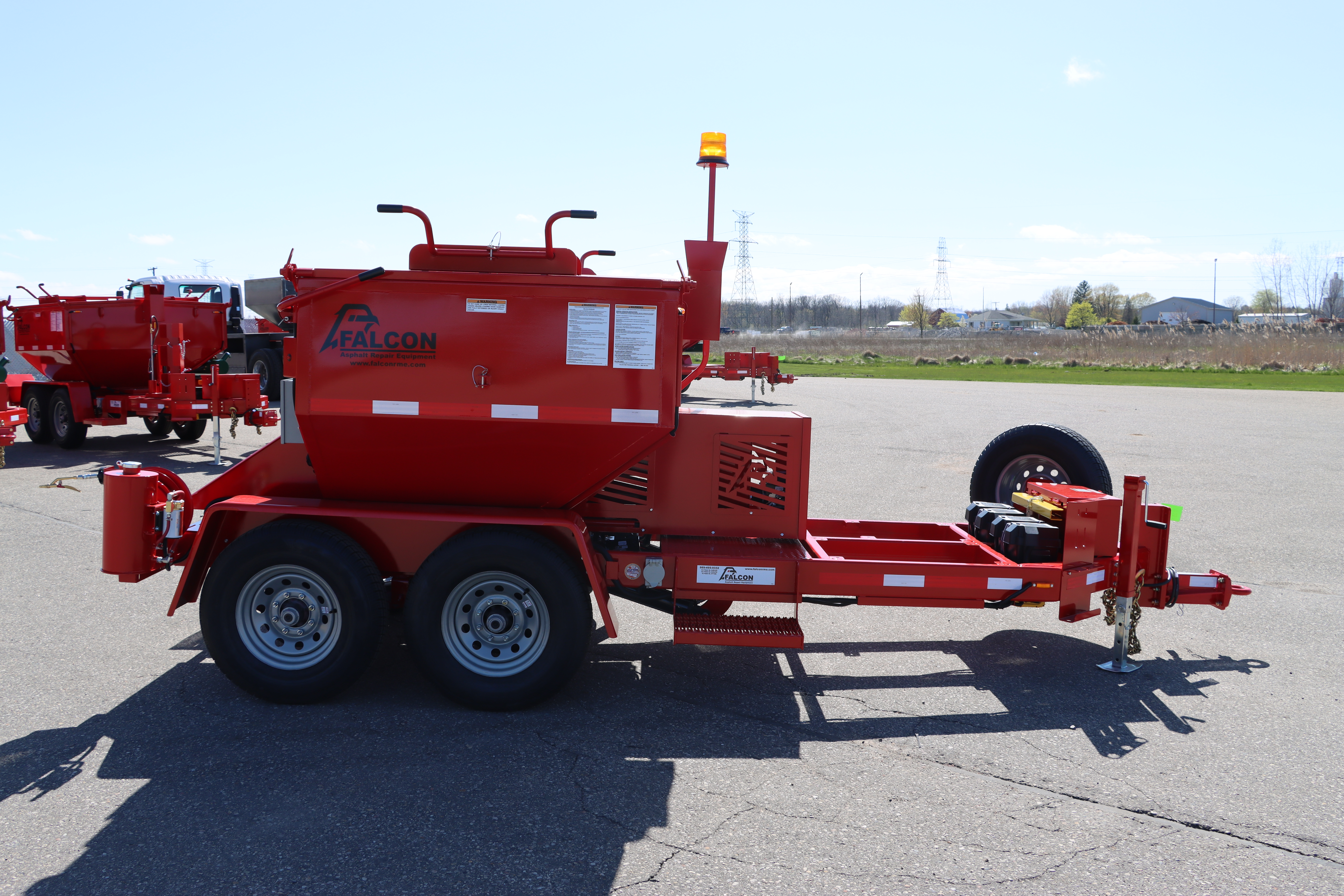 The front view of a red 6-ton Falcon asphalt hot box.