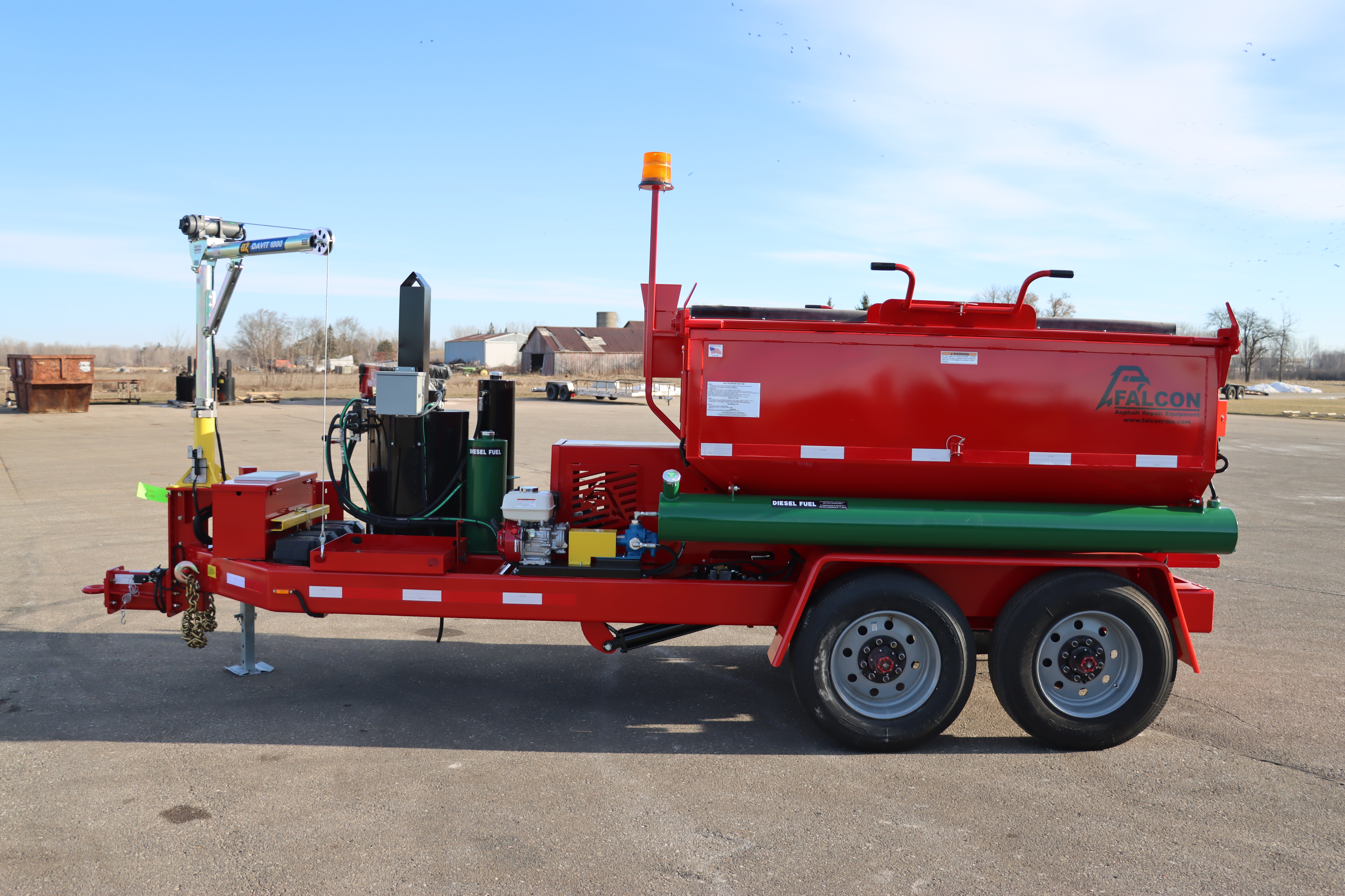 The front view of a red 6-ton Falcon asphalt hot box.